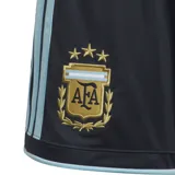 Short de fútbol Adidas de la Selección Argentina, modelo local 2026, para niños. Diseño azul oscuro con detalles celestes en los laterales y el escudo de la AFA bordado.