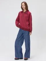 Buzo de algodón con cuello alto y cierre frontal parcial. Presenta bolsillos laterales con cierre y cuello con interior en contraste. Diseño de corte oversize.