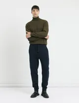Pantalón jogging de tejido circular con cintura elástica y cordón ajustable. Presenta puños elastizados en el ruedo y bolsillos laterales.