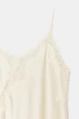 Vestido corto de satén con escote en pico y tirantes finos. Presenta aplicaciones de encaje en el escote y en el bajo, con un diseño asimétrico y abertura lateral.