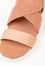 Sandalia negra con tiras cruzadas en el empeine y tira simple. Tira de ajuste en el tobillo. Plataforma de 3 cm de alto.