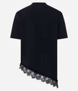 Remera de algodón color negro, de corte holgado y manga corta. Presenta un diseño asimétrico en el ruedo con una aplicación de encaje delicado en el borde inferior.