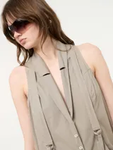 Mono color beige con bolsillos delanteros y tirantes ajustables.