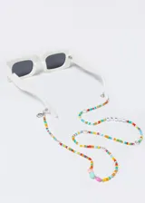 Correa para lentes con mostacillas de colores y cuentas con forma de corazón.