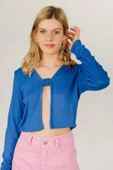 Top corto azul de tejido de punto acanalado, con mangas largas y cierre frontal con hebilla.