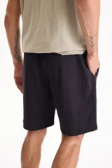 Bermuda deportiva sin friza color azul marino, con cintura elástica con cordón ajustable y bolsillos laterales.
