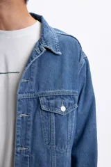 Campera de jean azul claro con bolsillos frontales con solapa y botones metálicos.