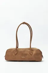 Cartera baguette color marrón claro, confeccionada en símil cuero con formato cilíndrico y doble asa corta.