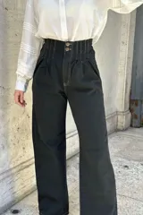 Pantalón de jean color beige, de corte ancho, recto y de tiro alto. Tiene elástico y pinzas en la pretina.