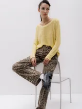 Sweater de punto color amarillo, con cuello redondo y mangas largas. Corte regular y textura suave.