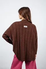 Sweater marrón de punto trenzado con cuello alto y mangas largas.