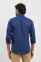 Camisa azul de manga corta, con cuello abotonado y bolsillo en el pecho.
