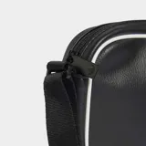 Bolso bandolera Adidas Adicolor Classic Airliner negro de cuero sintético con logo blanco. Tiene correa ajustable, compartimento principal con cierre y bolsillo frontal con cierre.