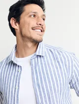 Camisa de lino a rayas verticales color beige y blanco, de corte clásico, con cuello abotonado y mangas largas.