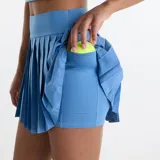 Pollera deportiva plisada color celeste de talle alto, con short interno integrado.