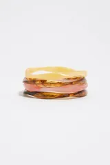 Pack de tres pulseras rígidas de resina en tonos tostado, marrón carey y rosado translúcido, con diseño de formas orgánicas.