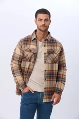 Campera estilo leñadora de viyela a cuadros en tonos beige, marrón y azul, con interior forrado en corderito, cierre frontal con botones y dos bolsillos con solapa en el pecho.