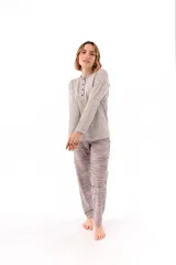 Pijama de dos piezas compuesto por una remera de manga larga con cuello redondo y cartera de botones, y un pantalón largo de corte recto. Ambas prendas presentan un estampado geométrico sutil en tonos gris y azul.