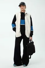 Pantalón de punto de pierna ancha, color negro con franjas laterales en tono azul. Presenta cintura elastizada y un diseño holgado que aporta comodidad.