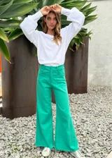 Pantalón de jean verde con corte palazzo y ruedo desflecado.
