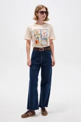 Remera de algodón color beige con cuello redondo y diseño holgado, con estampado frontal de ilustraciones estilo postal con bebidas y frutas.