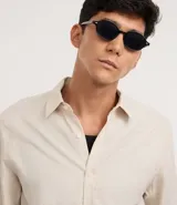 Camisa de manga larga confeccionada en tricolina de algodón, con cuello inglés, cierre frontal de botones y puños abotonados. Diseño liso y versátil.