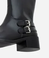 Bota de caña corta color negro, de PU (cuero sintético), con taco bloque bajo, punta levemente redondeada y dos tiras con hebillas metálicas en el lateral.