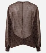 Blusa de poliamida con estampado geométrico, diseño amplio y fluido, escote en V con cierre frontal de botones, mangas largas abullonadas con puños ajustados y acabado con sutil transparencia.