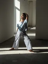 Pijama de algodón a rayas, compuesto por una remera de manga corta con cordones ajustables en los laterales y un pantalón de corte recto y holgado.