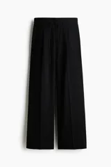 Pantalón de tiro alto con piernas amplias, pinzas frontales y raya marcada. Cuenta con cierre oculto, cordón ajustable en la cintura, bolsillos laterales discretos y bolsillos traseros insertados.