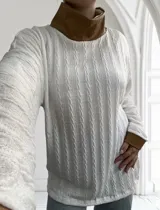 Polera blanca de tejido trenzado con cuello alto y puños de cuero marrón.