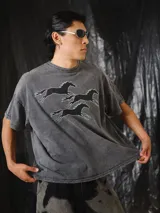 Remera oversize gris con efecto stone wash y estampado en serigrafía de caballos galopando con diseño pixelado.