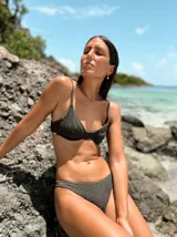 Top de bikini con aro, confeccionado en tela con textura brillante color verde militar. Posee breteles regulables y cierre mediante atadura en la espalda.