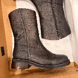 Bota corta de cuero con textura rugosa, color marrón oscuro con efecto desgastado. Presenta cierre lateral, costuras reforzadas y un taco bajo cuadrado de madera.