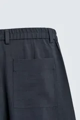 Pantalón de corte relaxed fit, con cintura ajustable, bolsillos delanteros y bolsillo trasero de plastrón. Presenta cierre frontal con cremallera y botón.
