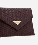 Billetera Satinato de tamaño pequeño, tipo sobre, confeccionada en PU con textura trenzada tressé de color bordó. Cuenta con solapa frontal con cierre de broche a presión y aplicación metálica triangular dorada con el logotipo de la marca.
