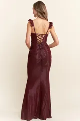 Vestido largo de corte sirena confeccionado en tejido brillante y elástico. Presenta un diseño ajustado con frunces en el torso, escote cuadrado y breteles con detalle de encaje tipo eyelash.