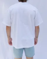 Remera blanca de algodón con cuello redondo y bolsillo en el pecho con logo estampado en azul.