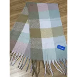 Bufanda rectangular de tejido grueso con diseño de cuadros en tonos pastel y neutros. Presenta flecos en los extremos y etiqueta de la marca United Uy.