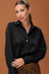 Camisa de seda negra con cuello clásico, cierre frontal con botones y mangas largas con puños ajustados.