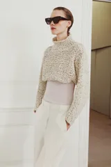 Jersey cropped de punto con textura de cinta entrelazada, cuello subido y manga larga.