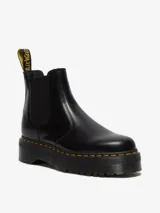 Bota Chelsea negra de cuero con refuerzos elásticos laterales, plataforma de 4 cm y suela tipo comando con cámara de aire. Presenta costuras amarillas en la vira Goodyear y una tira de tela amarilla con el logo "AirWair" en la parte trasera.