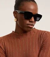 Suéter de punto de la marca Cortelle, con cuello redondo, mangas largas y diseño de rayas verticales texturizadas con hilos metalizados incorporados.