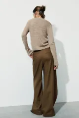 Pantalón de tiro medio confeccionado en mezcla de lino, con diseño de pierna recta y detalle de superposición frontal tipo pareo. Cuenta con cierre frontal mediante cremallera, botón y gancho metálico.