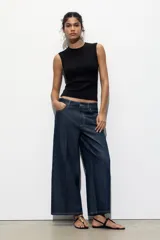 Top blanco de manga sisa con cuello redondo y corte ajustado al cuerpo.