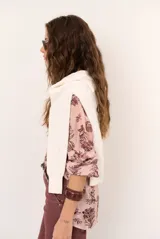 Camisa blanca de manga larga con estampado botánico en tono oscuro, cuello mao y escote en V con cierre frontal parcial de botones.