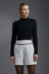 Blusa negra de punto con cuello alto y mangas largas.