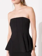 Top strapless negro con volados en la parte inferior y cierre en la espalda.