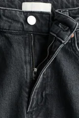 Jean de tiro alto con corte wide leg, confeccionado en denim de algodón con leve elasticidad. Presenta diseño clásico de cinco bolsillos, cierre frontal con botón y pernera amplia.