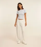 Conjunto de pijama largo de rib más sostenible, compuesto por una blusa de manga corta con escote redondo y detalle de flor aplicada, y un pantalón largo con cintura elástica, detalle de botones y estampa floral total.